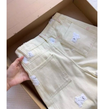 Quần jeans thêu nơ gấu nữ đầu xuân màu kem vàng - ống rộng, phong cách ngọt ngào, giảm tuổi, giá ưu đãi 321k