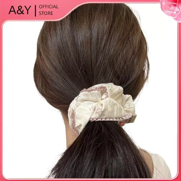 Những chiếc scrunchie thường kết hợp ren với viền vải để tạo cảm giác mềm mại và thẩm mỹ hơn. (Ảnh 2) Những chiếc scrunchie thường kết hợp ren với viền vải để tạo cảm giác mềm mại và thẩm mỹ hơn. (Ảnh 2)