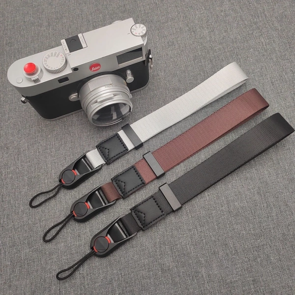 Thực tế dây đeo cổ tay camera giúp an toàn, nhưng lại làm phiền khi cần thay ống kính nhanh