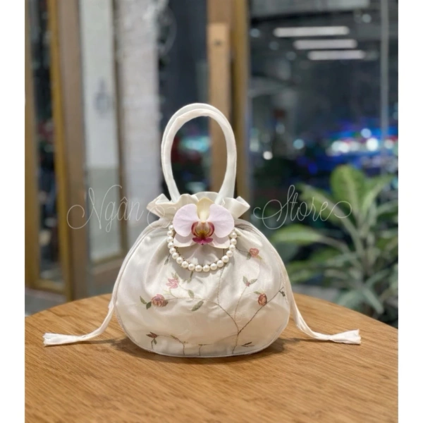 Để có cái nhìn khách quan, chúng ta có thể đặt chiếc túi gấm rút thêu hoa – phối hoa lan & vòng ngọc bên cạnh các lựa chọn phổ biến khác như túi xách mini da, túi vải canvas có ngăn chia, hay hộp đựng trang sức sang trọng. (Ảnh 5) Để có cái nhìn khách quan, chúng ta có thể đặt chiếc túi gấm rút thêu hoa – phối hoa lan & vòng ngọc bên cạnh các lựa chọn phổ biến khác như túi xách mini da, túi vải canvas có ngăn chia, hay hộp đựng trang sức sang trọng. (Ảnh 5)