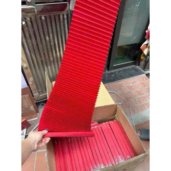 Giấy đỏ gấp nếp làm bừng sáng góc nhà ngày Tết, nhưng bất ngờ che khuất lối vào khiến không gian trở nên chật hẹp.